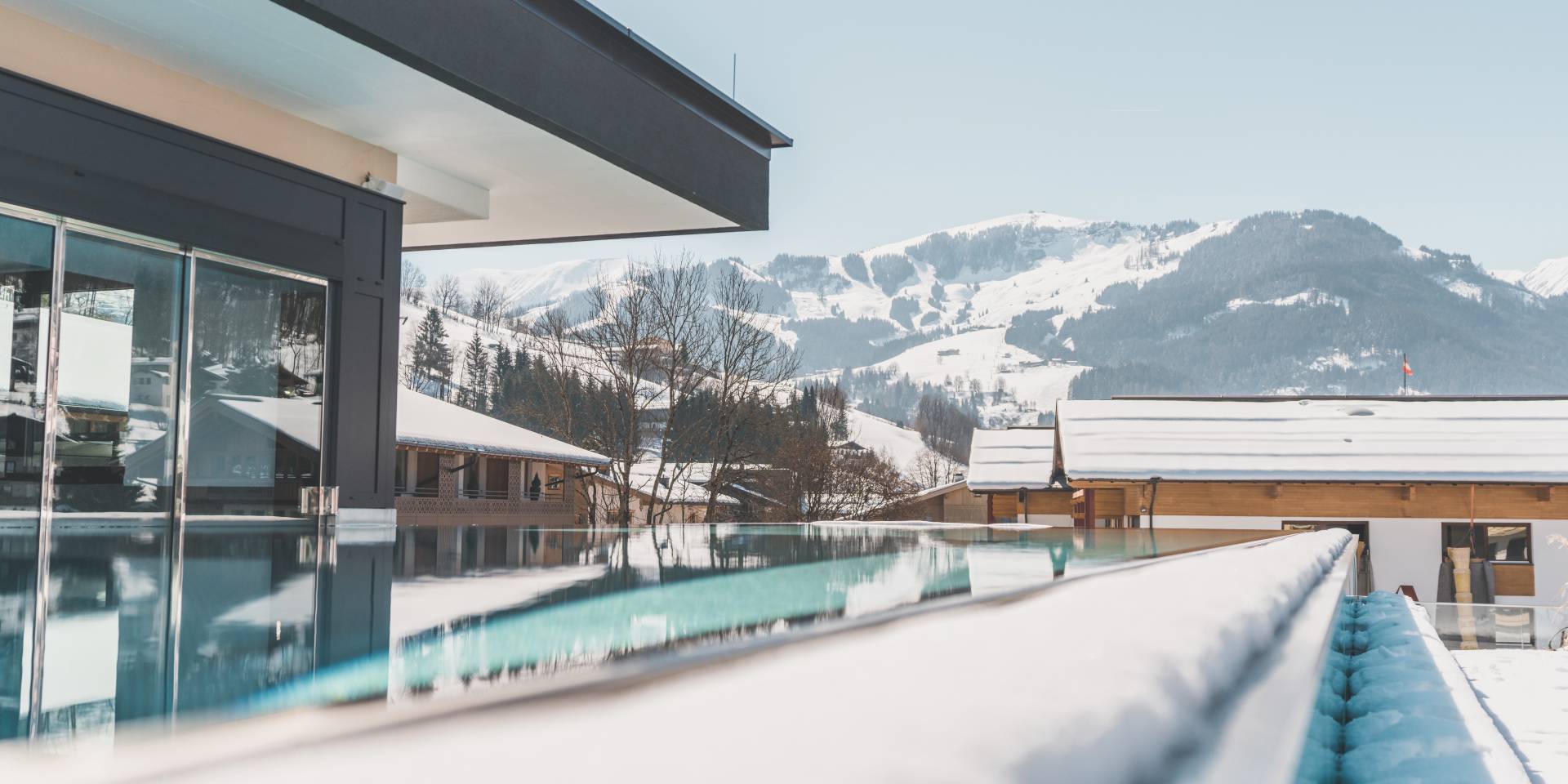 Infinity Pool mit Aussicht auf die schneebedeckten Berge in der HOCHKÖNIGIN in Maria Alm