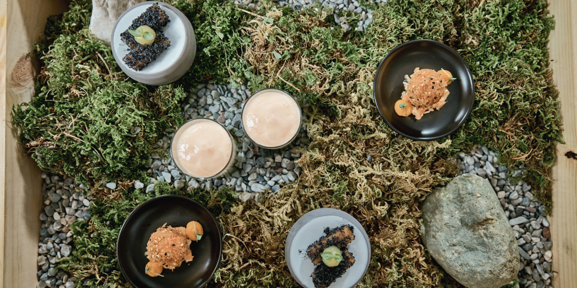 Moss tray photographed from above on which three different starters are presented