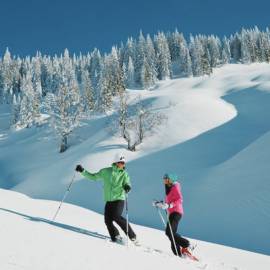 Couple snowshoeing in the snowy winter landscape in the mountains in Salzburger Land