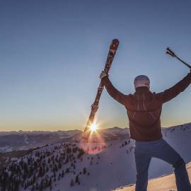 Skitourengeher am Gipfel bei Sonnenaufgang