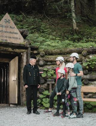 Family with guide in typical miner's uniform in the Barbarastollen