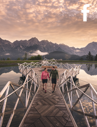 Paar beim Sonnenuntergang auf einer Brücke am Prinzensee mit fantastischem Blick auf die Berge