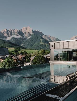 Ausblick vom SPA Fenster der HOCHKÖNIGIN über den Thermalwasserpool auf das Steinerne Meer und den Ort Maria Alm mit seinem Kirchturm