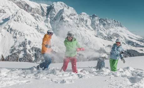 Familie im Schnee in den Bergen beim Skifahren