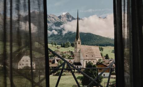 Ausblick aus dem SPA Fenster der HOCHKÖNIGIN auf das Steinerne Meer und den Ort Maria Alm mit seinem Kirchturm