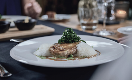 Hauptspeisengericht mit Fleisch, welches auf einem Teller am Abendtisch serviert wurde