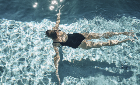 Schwimmende Frau von oben im Pool