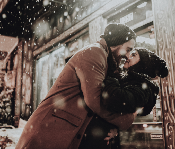 Man and woman embrace in the snowfall