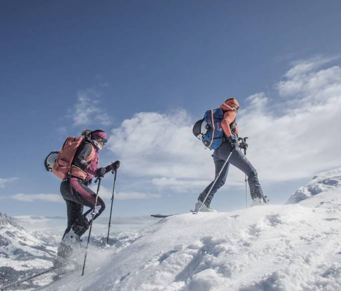 Group ski touring in the mountains with blue sky and snow the mountains in the background 